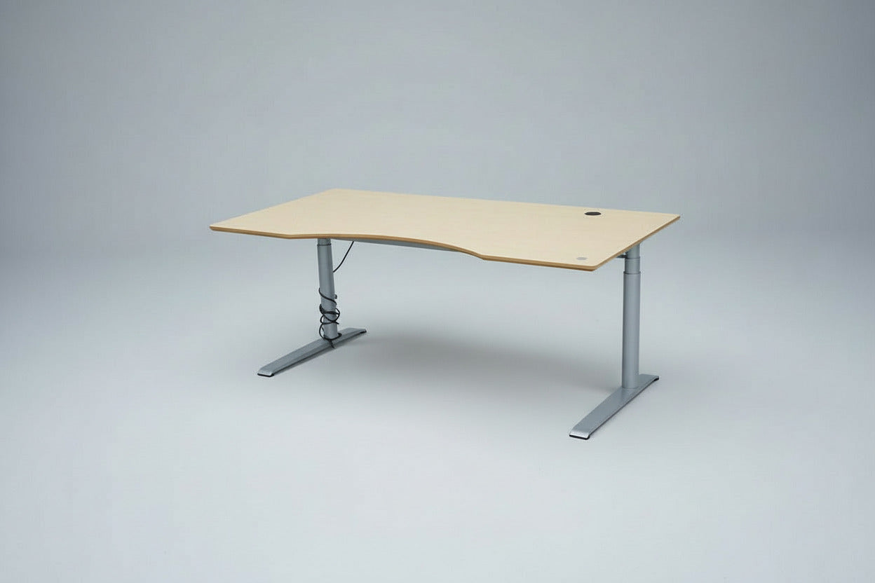 Cube Design hæve-sænkebord i egetræ set fra skrå vinkel med mavebue, sølvgråt stel og kabelgennemføring, 180x90 cm.